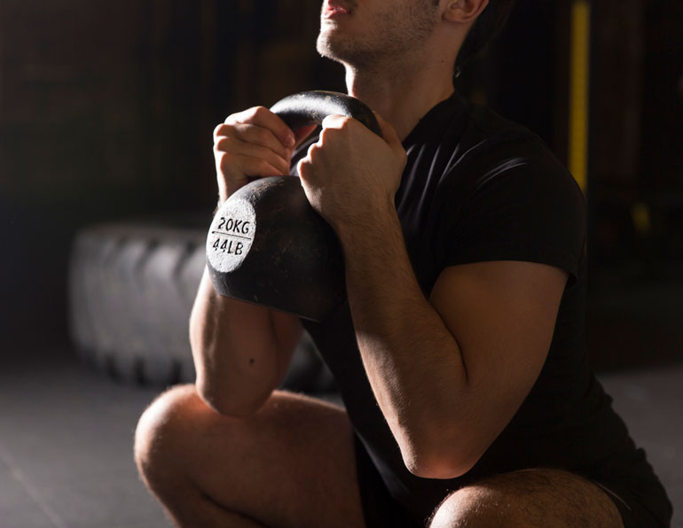man performing Goblet Squat with kettlebell