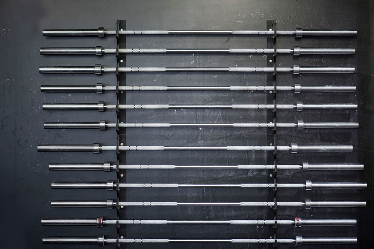 set of barbells stored on wall racks