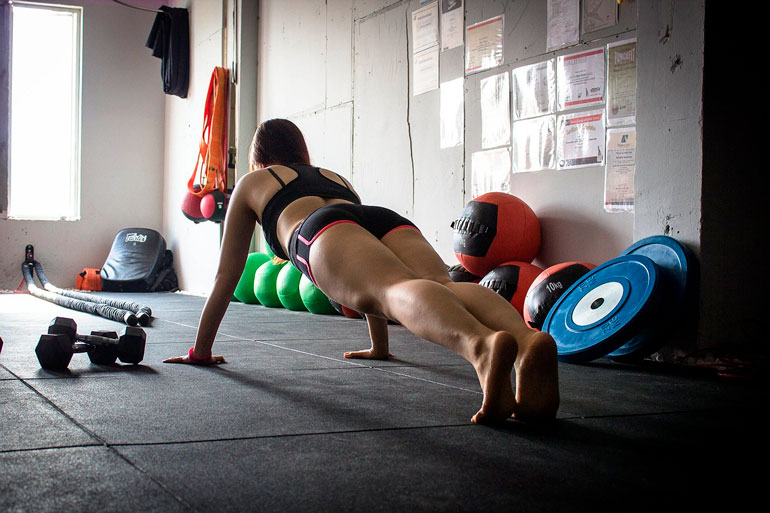 woman is doing Push Ups at home gym