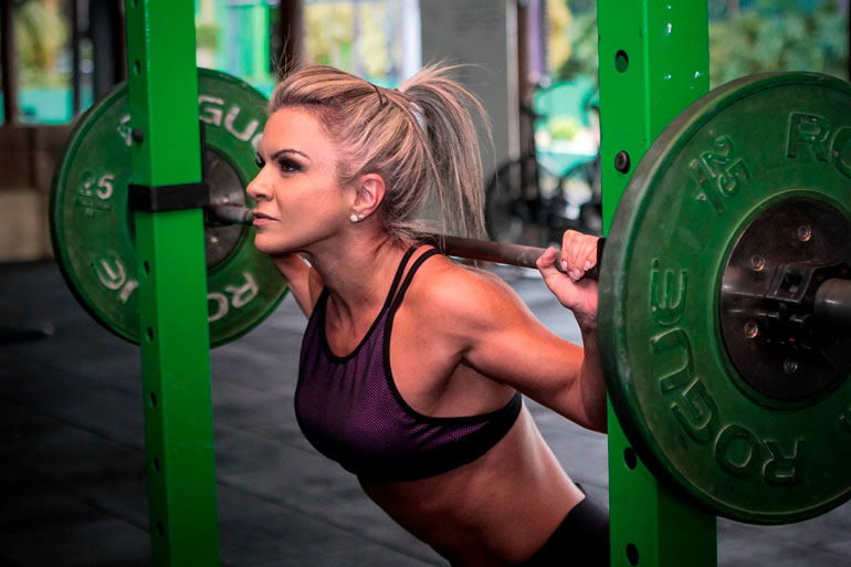 woman is weightlifting with green plates